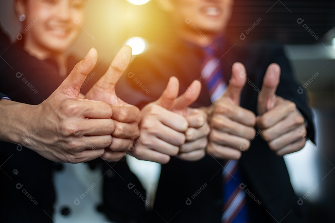 Grupo de negócios polegares para cima e fica sorrindo com confiança e rindo feliz na sala de conferências.