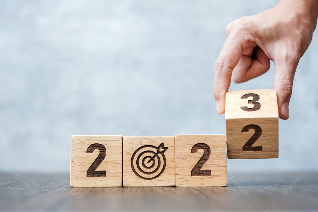 Virar a mão 2022 para 2023 bloco com placa de dardos. Meta de negócios