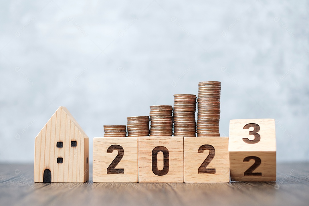 Virando para o bloco do ano 2023 com modelo de casa e moedas