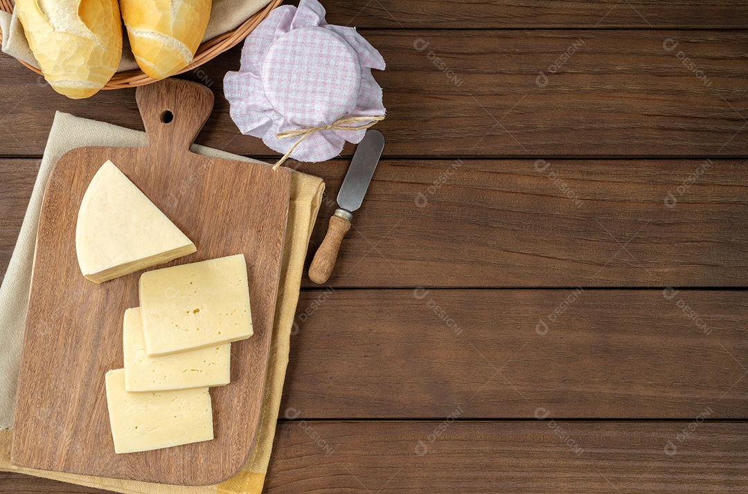 Queijo fresco artesanal de Canastra com café e pão sobre tábua de madeira.