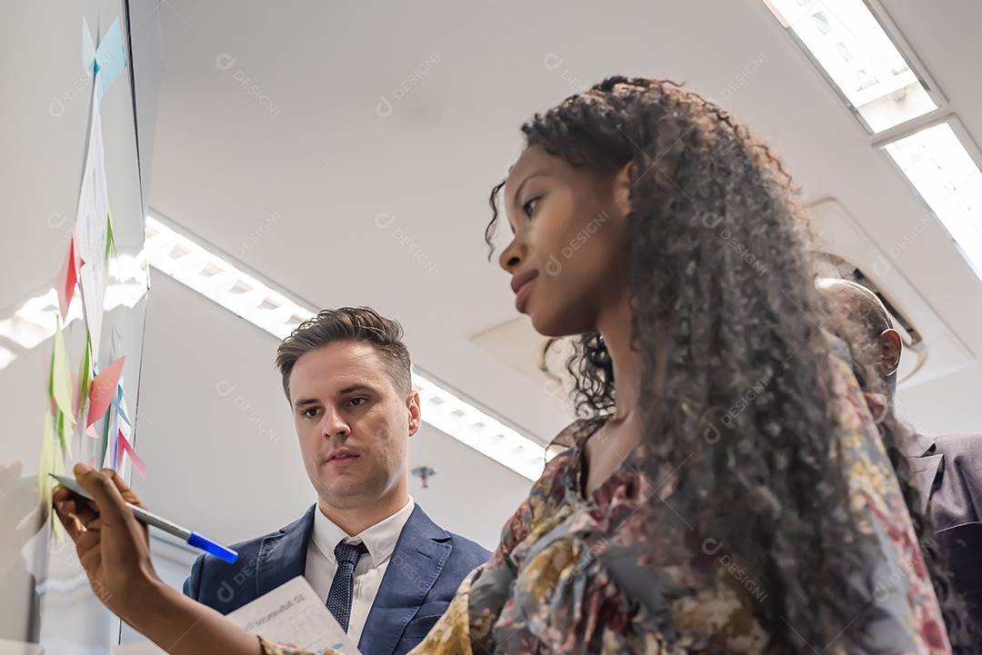Empresária africana escreve post-it no quadro branco em mederno