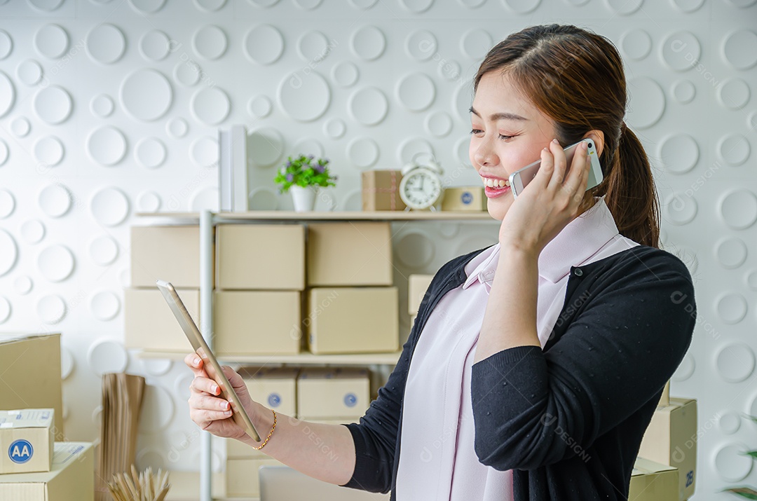 Linda mulher asiática sorria e verifique o produto da lista por tablet
