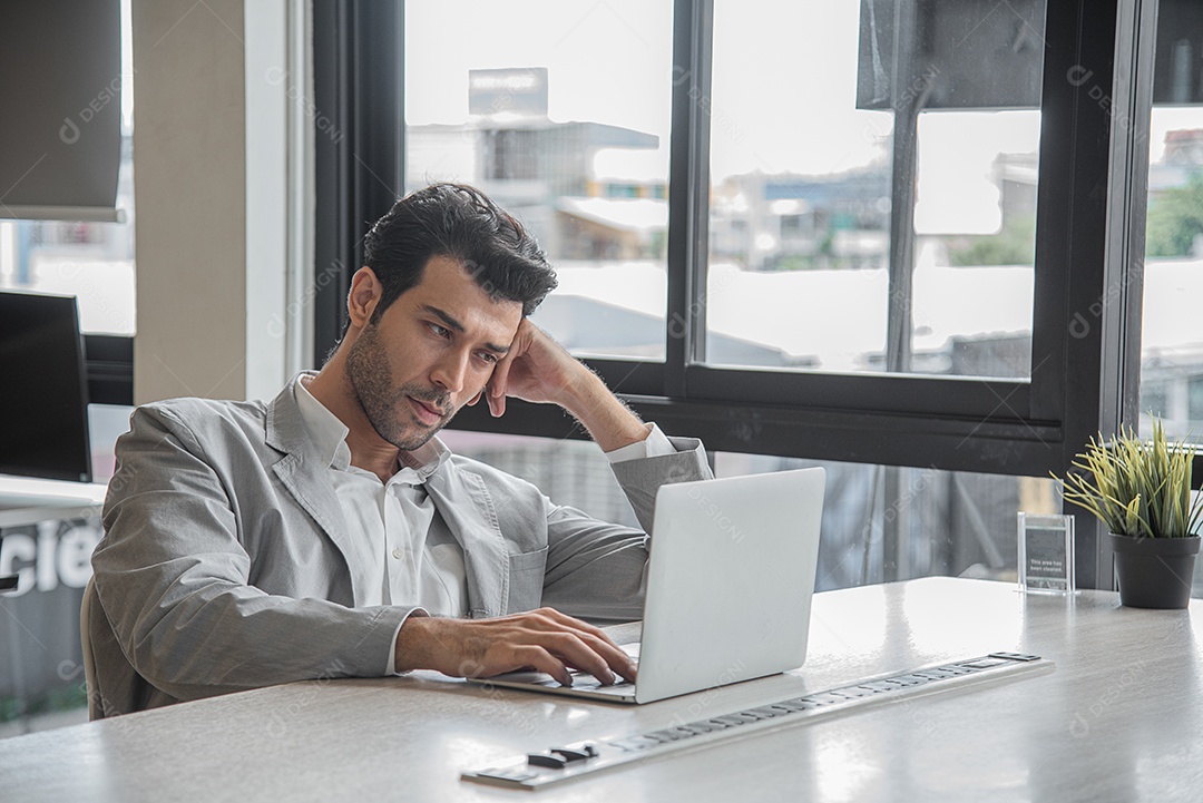 Homem de negócios sério e preocupado trabalhando com notebook de computador