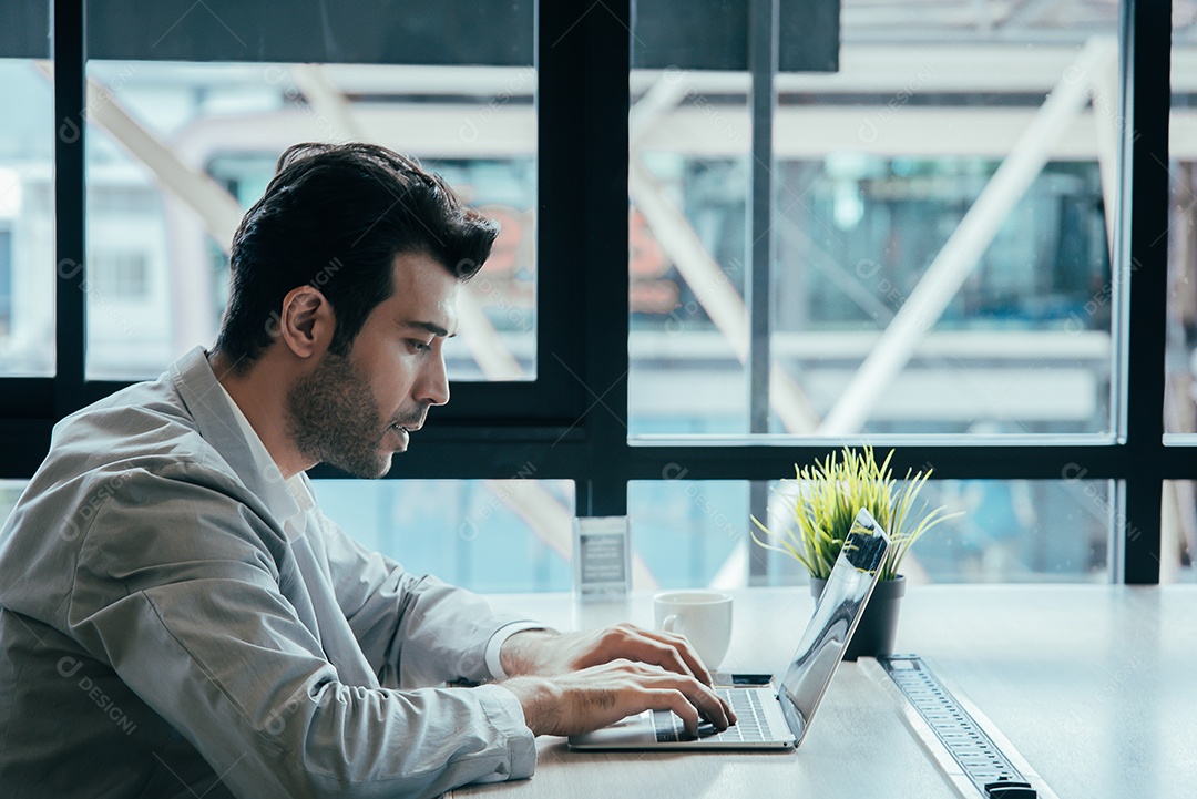 Homem de negócios trabalhando em seu laptop em um escritório