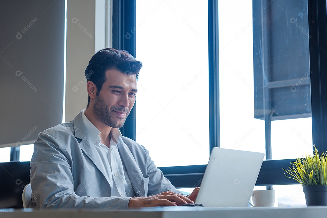 Homem de negócios trabalhando em seu laptop em um escritório