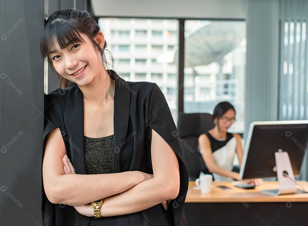 Mulher asiática de negócios confiante fica no escritório moderno