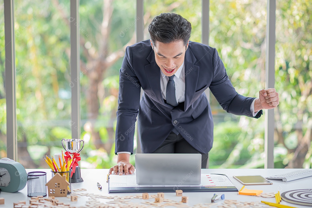 Empresário asiático levanta a mão e celebra o sucesso no trabalho