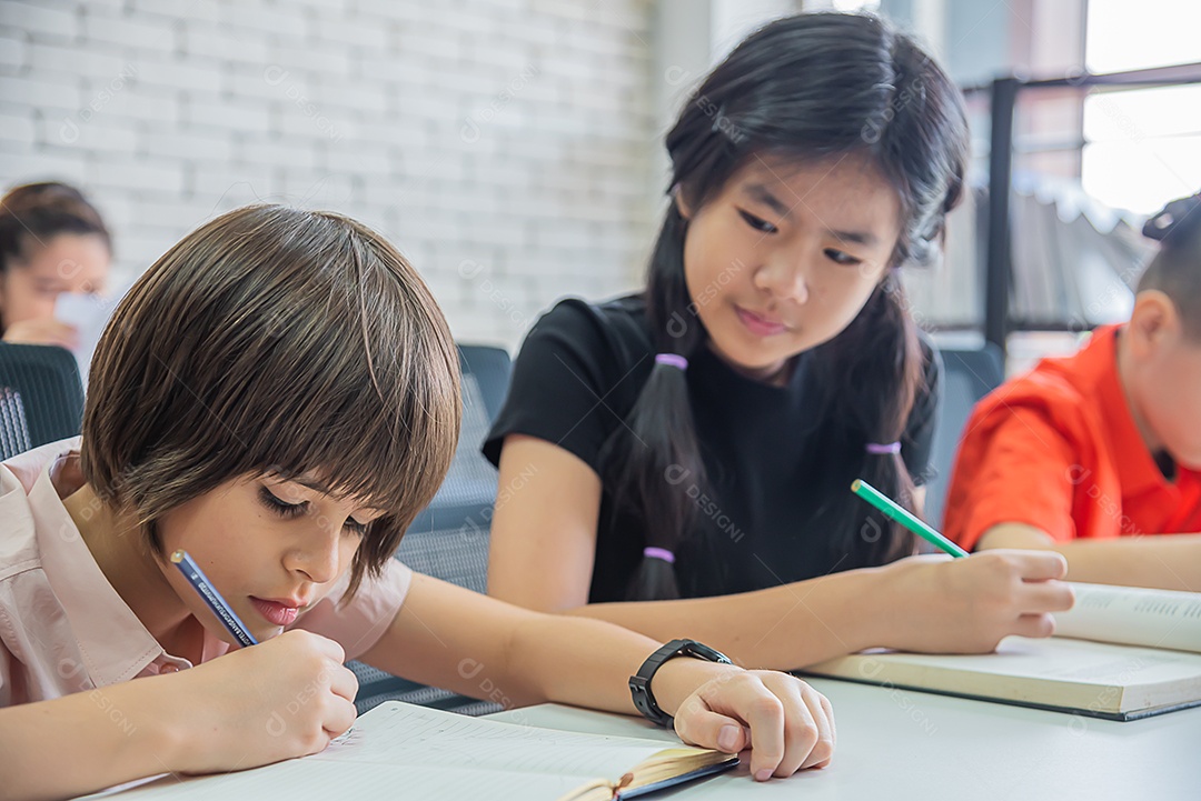 Alunos de menino sentado na sala de aula fazendo exercícios