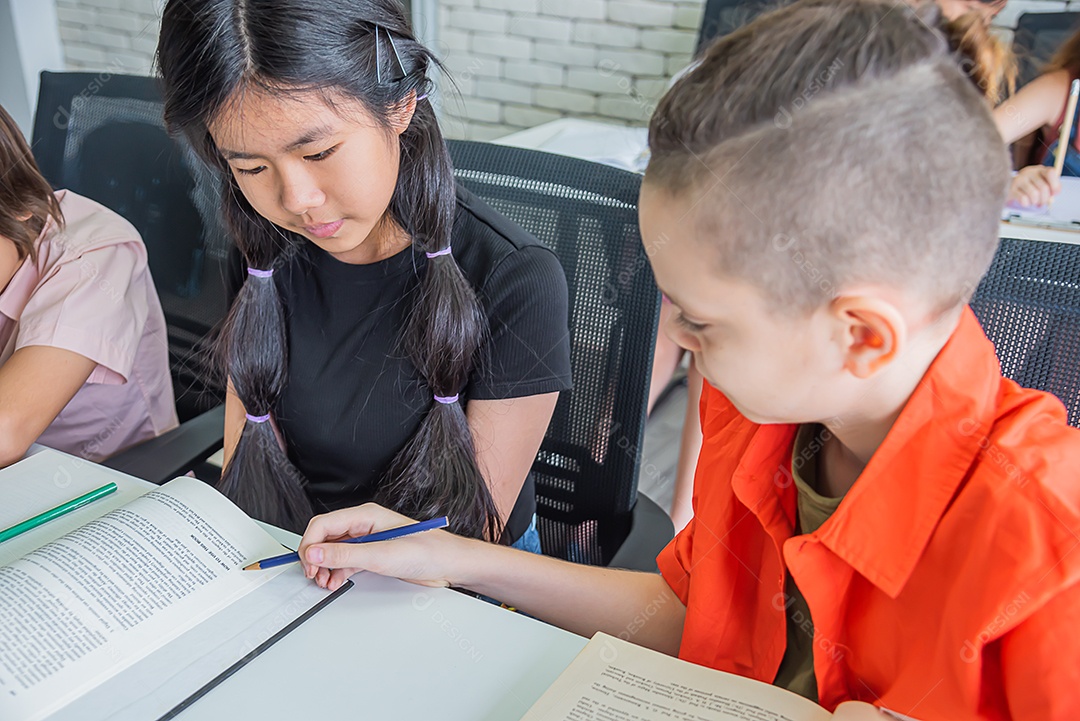 Estudante masculino ensinando amiga aluna em sala de aula