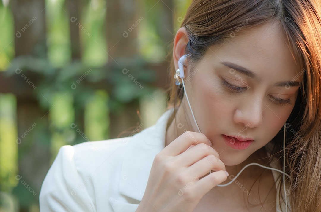Mulher usa fones de ouvido para ouvir música e relaxar