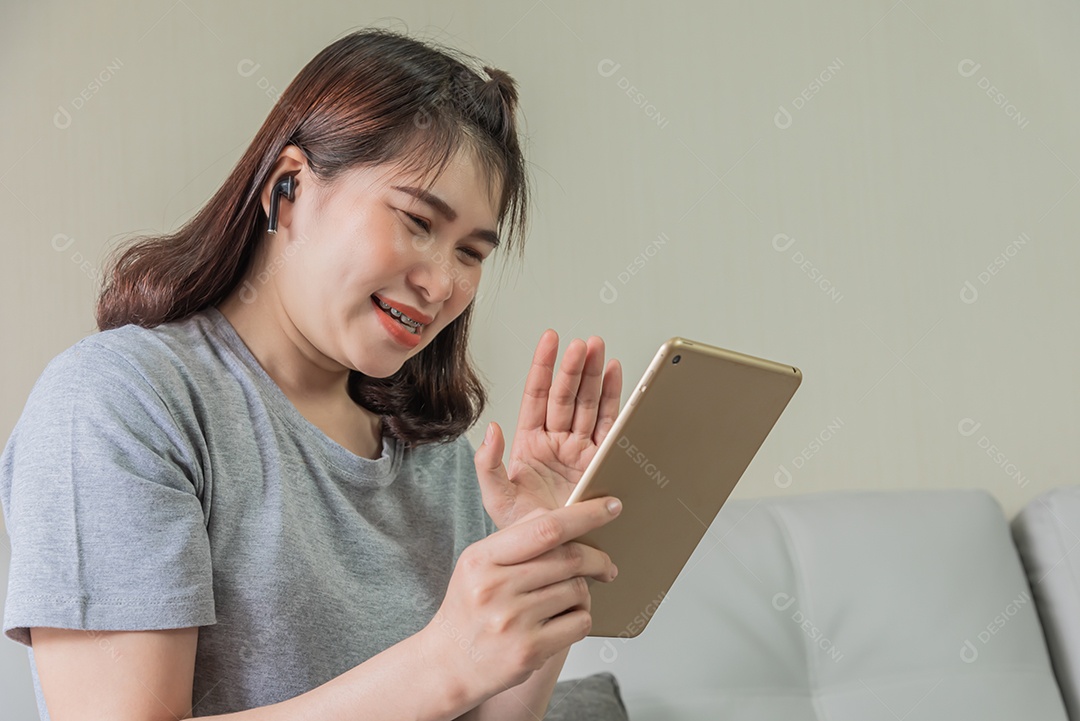 Mulher usa tablet e fone de ouvido assistindo câmera social