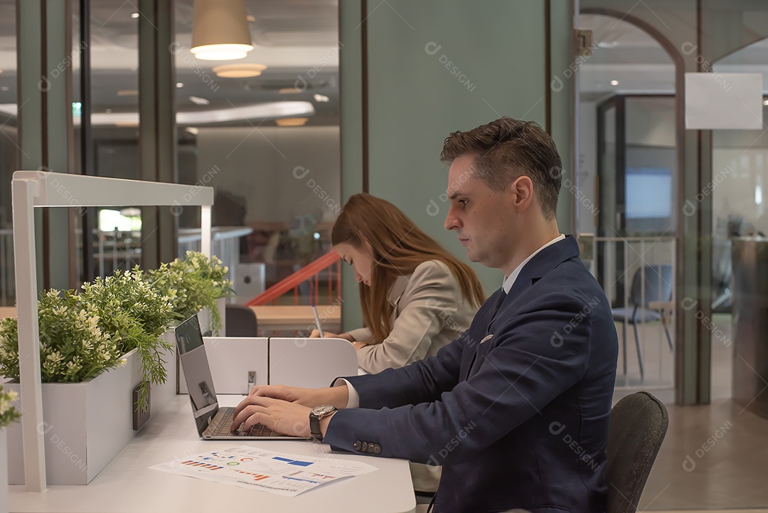 Homem de negócios usa notebook de computador em fundo de escritório moderno