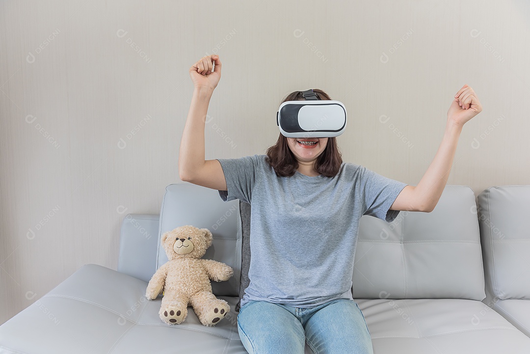 Mulher asiática jogando videogame com óculos VR em casa