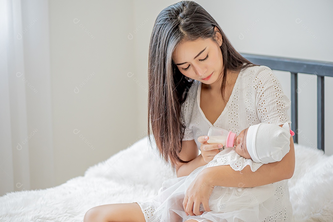 Bebê dorme no colo da mãe, mãe asiática carrega e toca nele