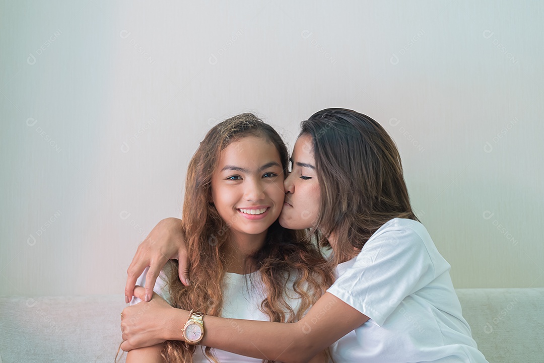 Mãe demonstra amor pela filha beijando sua bochecha