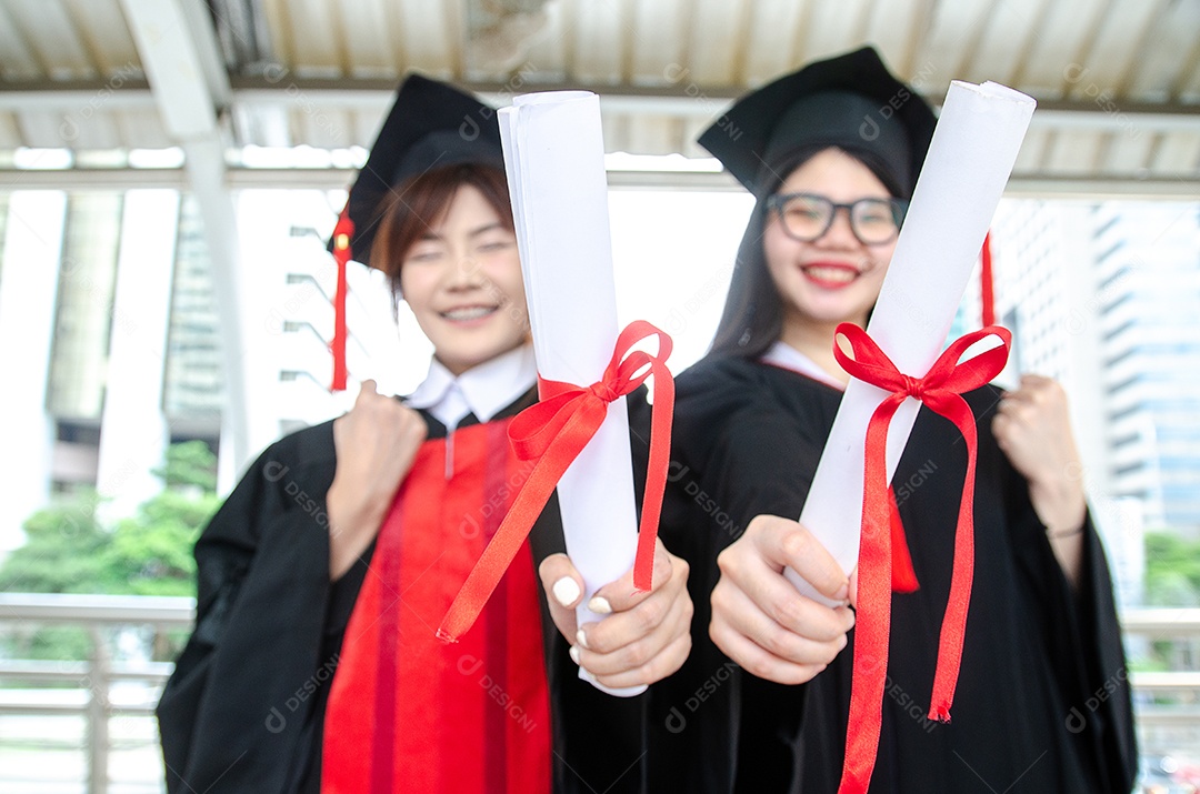 Dois estudantes universitários mulheres asiáticas usam vestidos de formatura