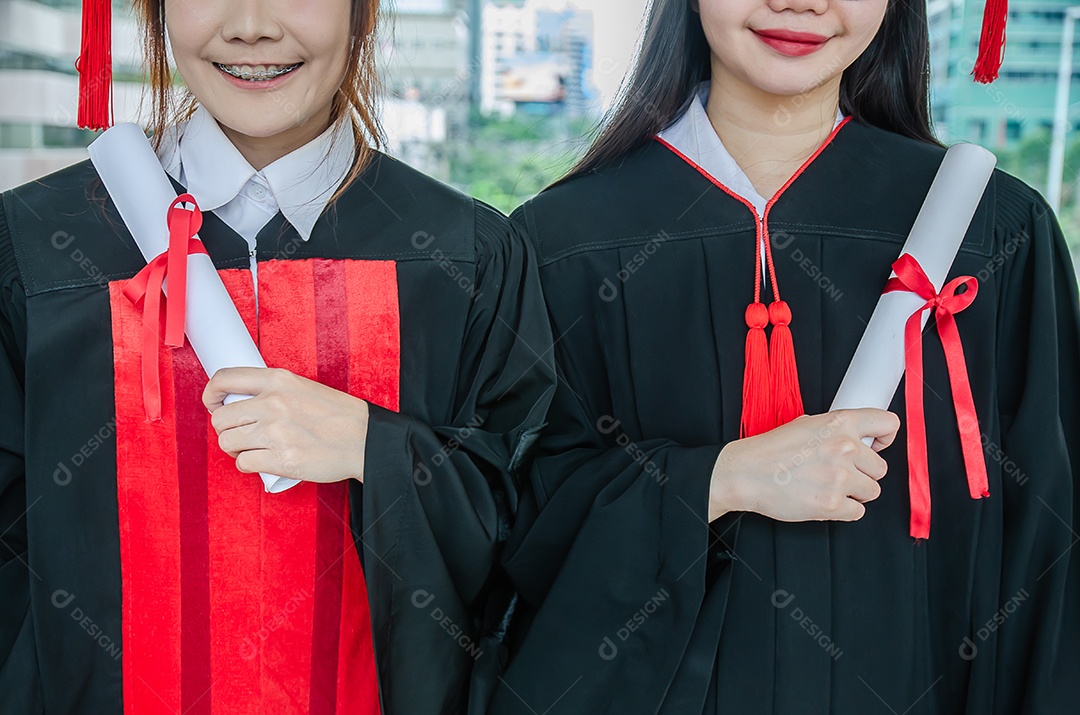 Dois estudantes universitários mulher asiática usam vestidos após a formatura