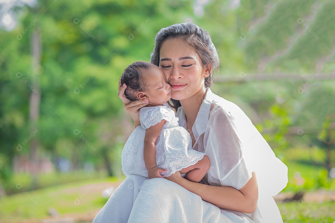 A mãe bonita asiática abraça seu bebê enquanto dorme