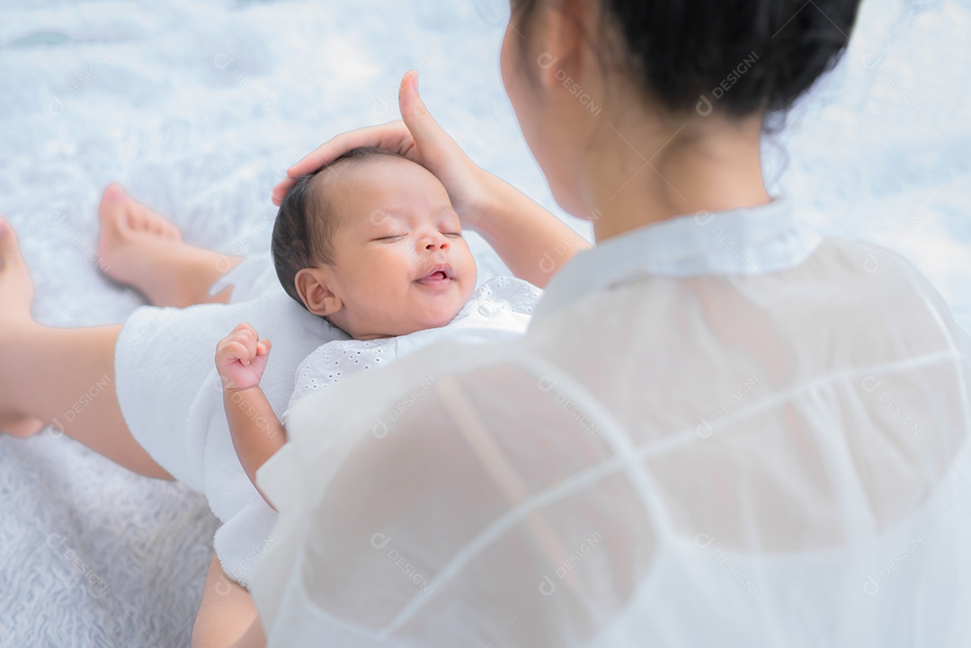 Bebê dorme no colo da mãe, mãe carrega e toca seu filho