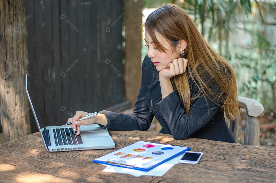Linda mulher de negócios asiáticos usa notebook de computador em cafeteria