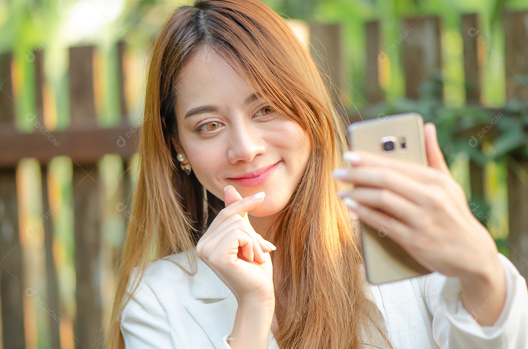 Linda mulher de negócios asiáticos usa telefone inteligente falando com seu amigo, família interior, feliz e sorriso.