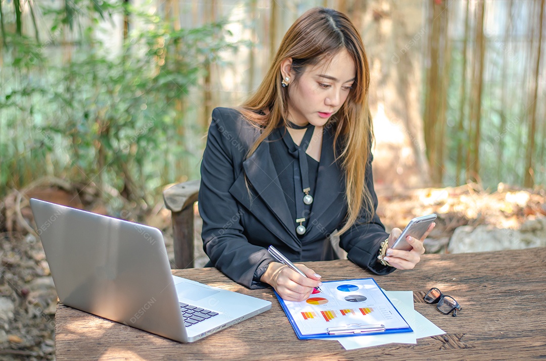 Mulher de negócios usa telefones inteligentes para verificar e-mail, procurar mídia social, fazer compras online, jogar, internet banking, pagar conta.