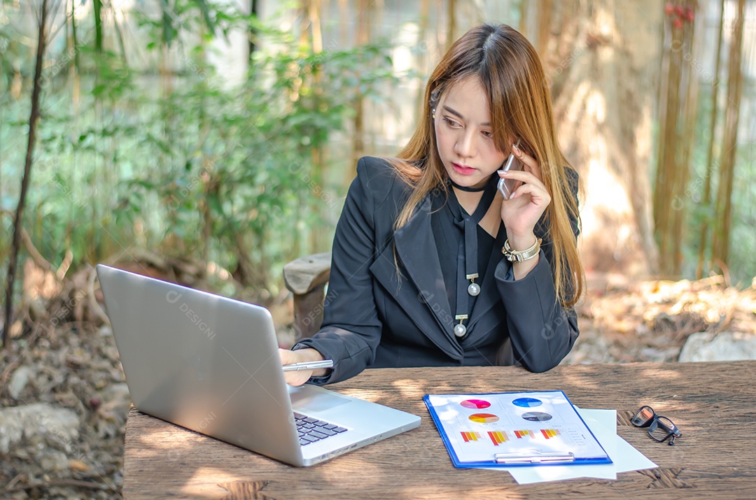 Mulher de negócios usando telefones inteligentes para verificar e-mail, procurar mídia social, fazer compras online, jogar, internet banking, pagar conta.