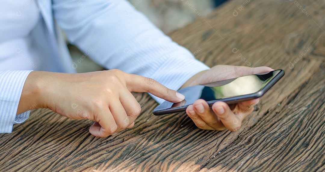 Homem de negócios usa telefones inteligentes para verificar e-mail, procurar mídia social, fazer compras online, jogar, internet banking, pagar conta.