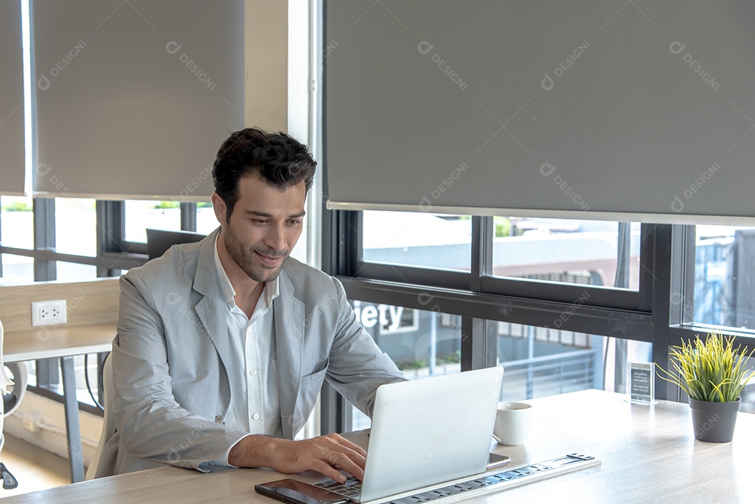 Homem de negócios usando computador portátil no local de trabalho.