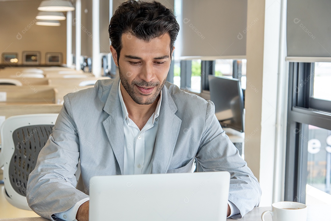 Homem de negócios usa computador portátil no local de trabalho.