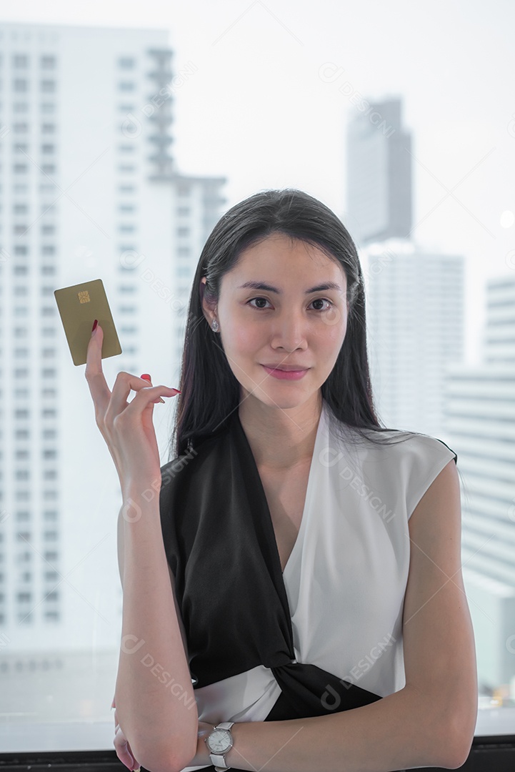 Mulher asiática de negócios segurando o cartão de crédito.
