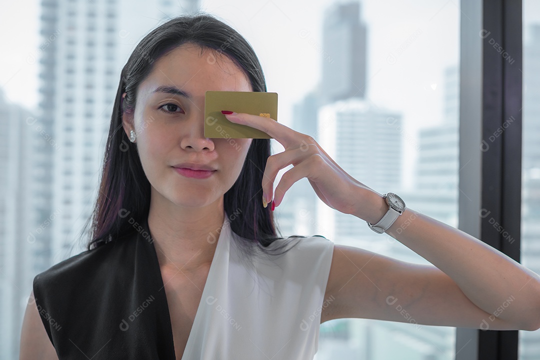 Mulher asiática de negócios segurando o cartão de crédito.