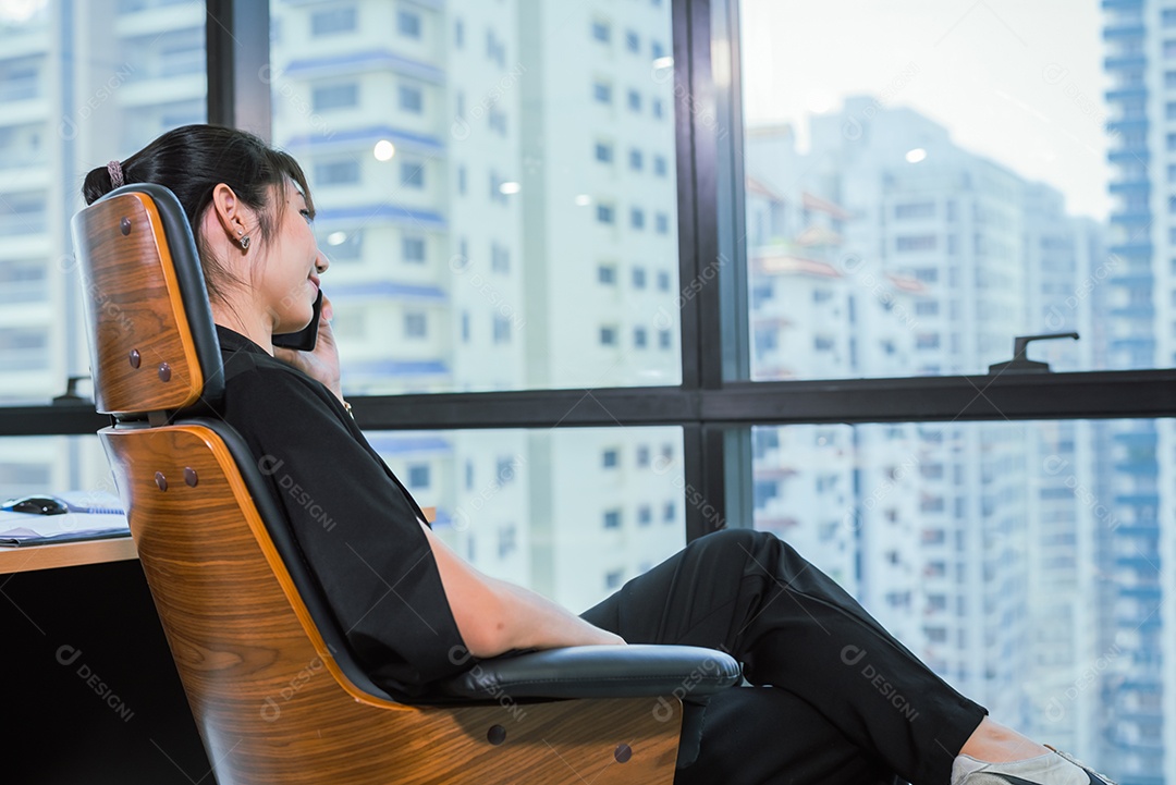 Mulher de negócios sente-se relaxe na cadeira, use o telefone móvel.