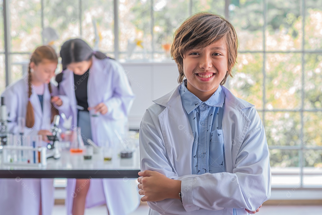 Estudante do sexo masculino estudando aula de ciências em pé na frente da classe.