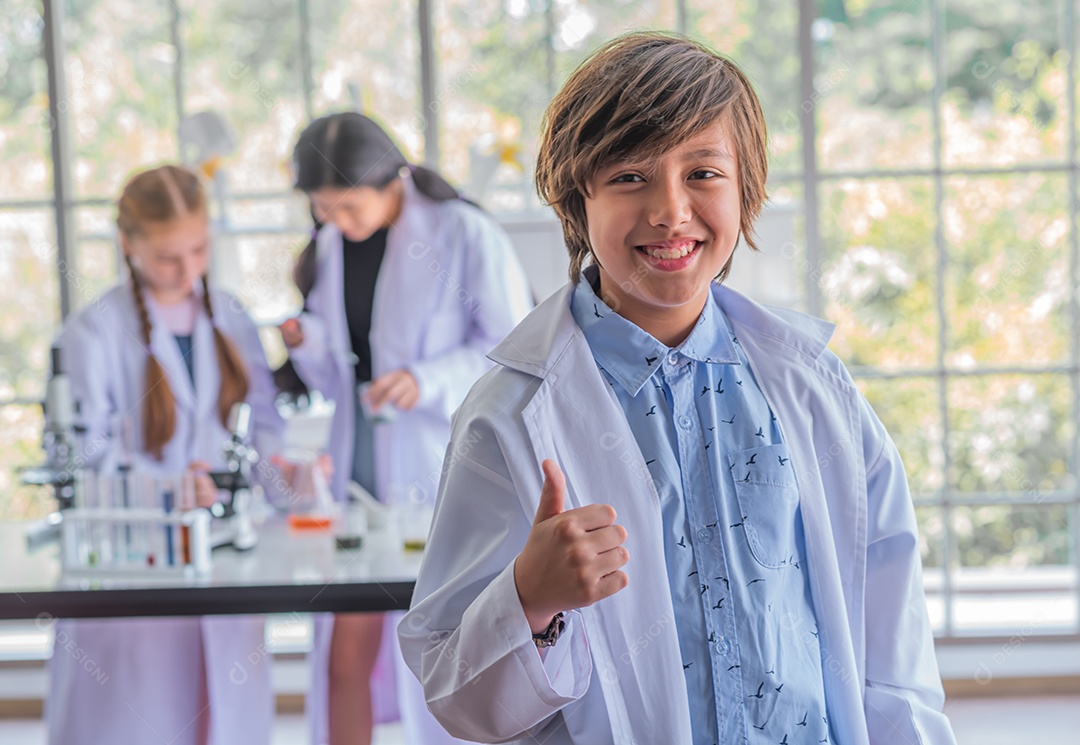 Estudante do sexo masculino estudando aula de ciências em pé na frente da classe.