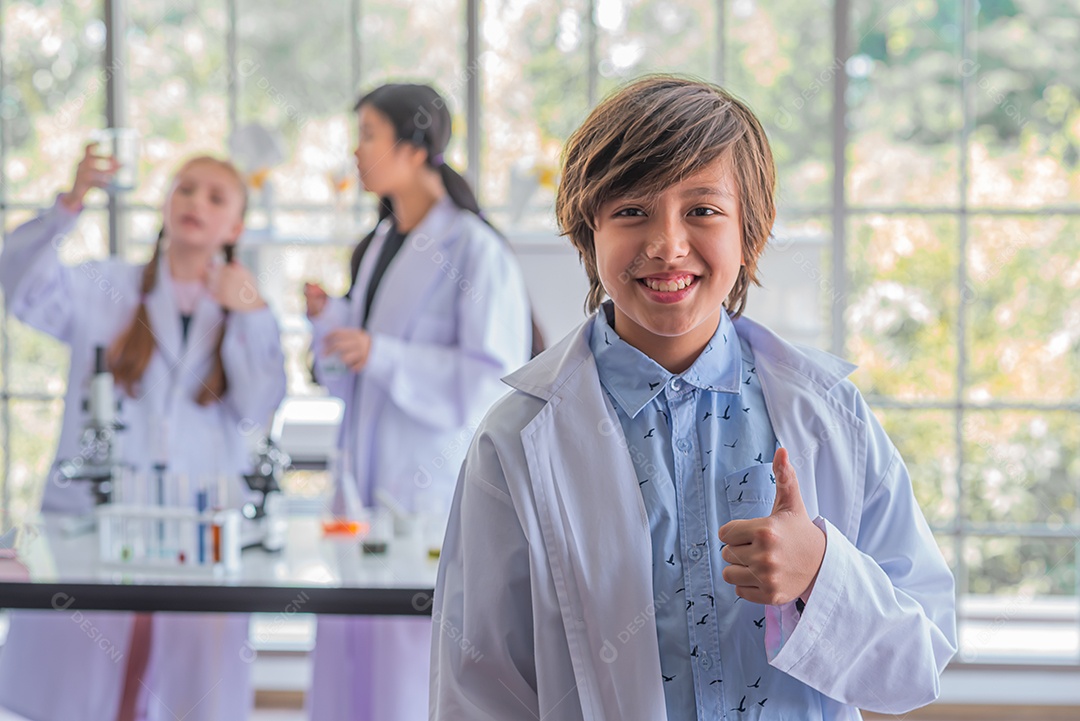 Estudante do sexo masculino estudando aula de ciências em pé na frente da classe.