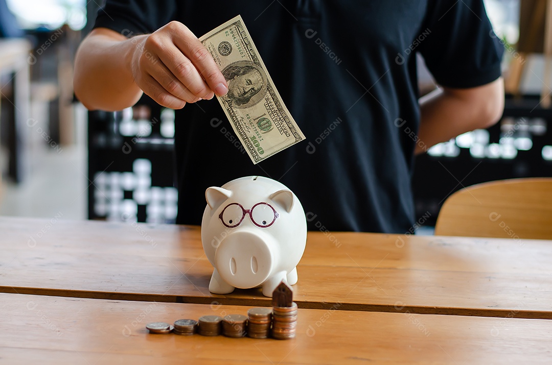 Homem economizar dólar para o plano de comprar casa e pilha de moedas, cofrinho.