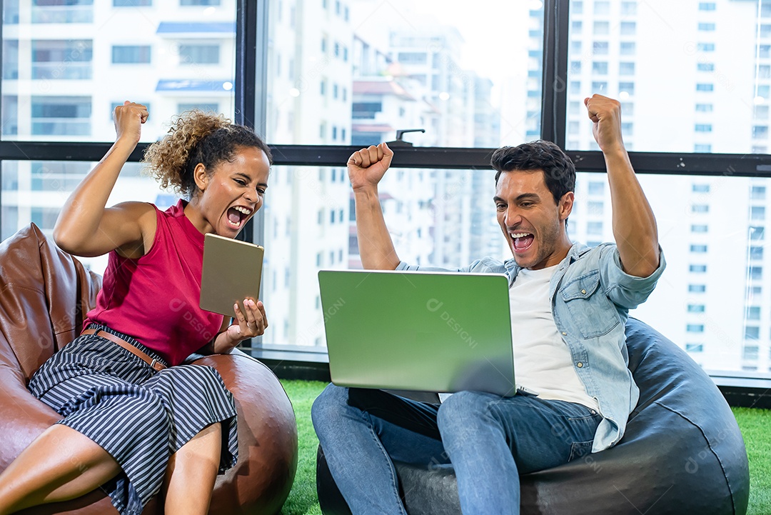 Jovem e mulher africana estão felizes enquanto procuram tablet.