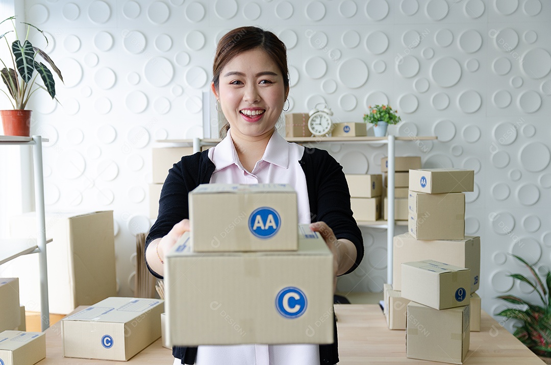 Linda mulher asiática sorria e segurando a caixa fique feliz em vender muitos produtos.