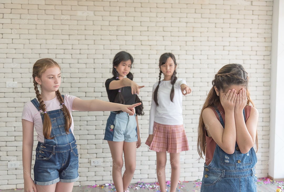 Colegas do ensino fundamental apontam para uma amiga que chorou por não ter ajudado na atividade.