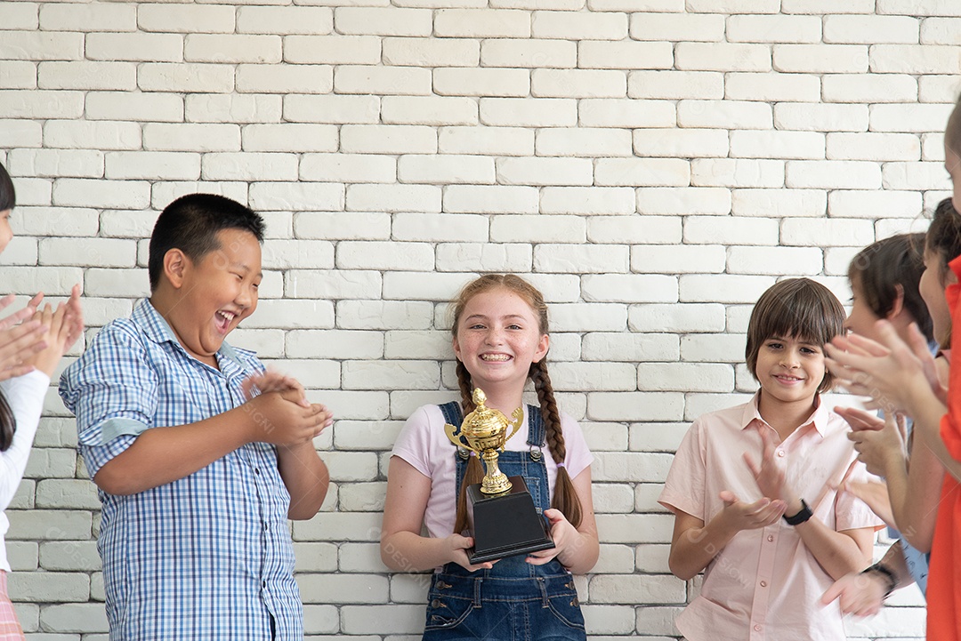 Estudantes masculinos e femininos do ensino fundamental de uma escola internacional ficam na frente da sala de aula.