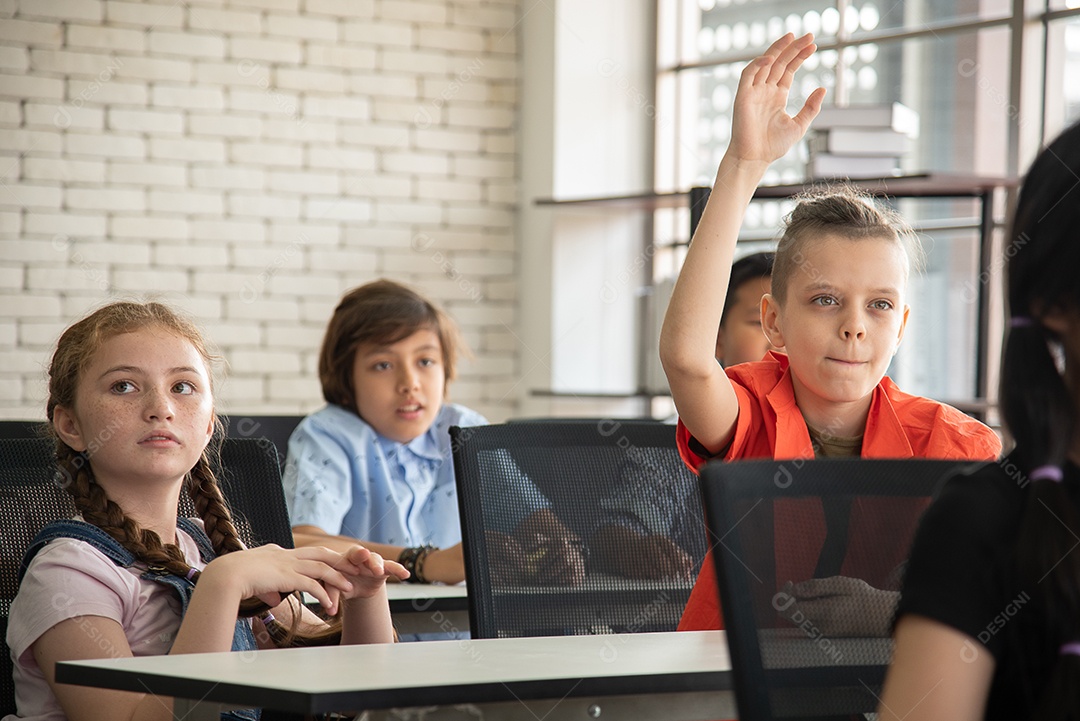 Alunos do ensino fundamental conversando durante o intervalo para o almoço na sala de aula sorrindo alegremente.