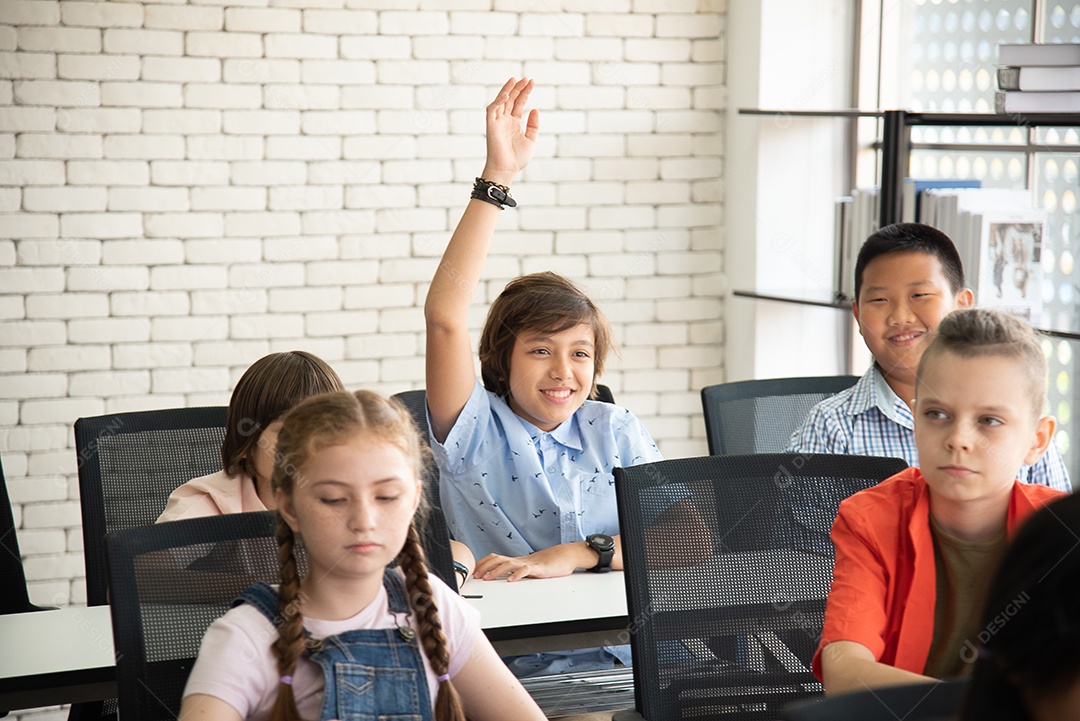 Alunos do ensino fundamental conversando durante o intervalo para o almoço na sala de aula sorrindo alegremente.