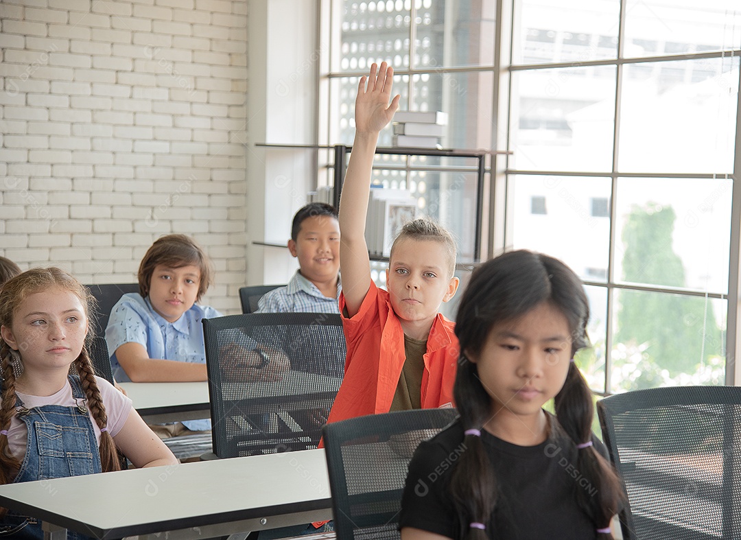 Alunos do ensino fundamental conversando durante o intervalo para o almoço na sala de aula sorrindo alegremente.