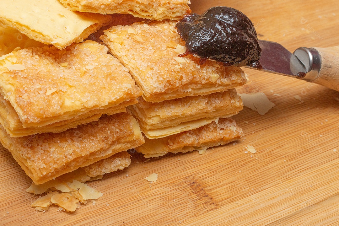 biscoitos de massa folhada empilhados perto de colher de geleia