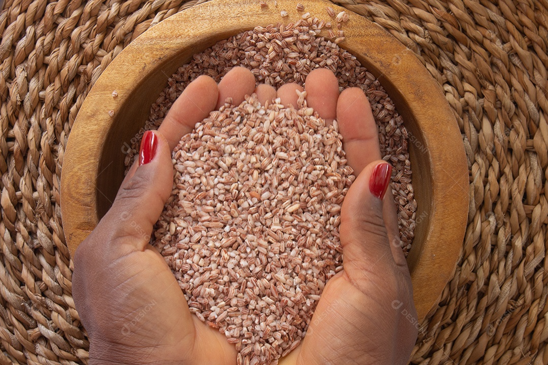 mãos segurando arroz orgânico e cru em uma tigela - comida