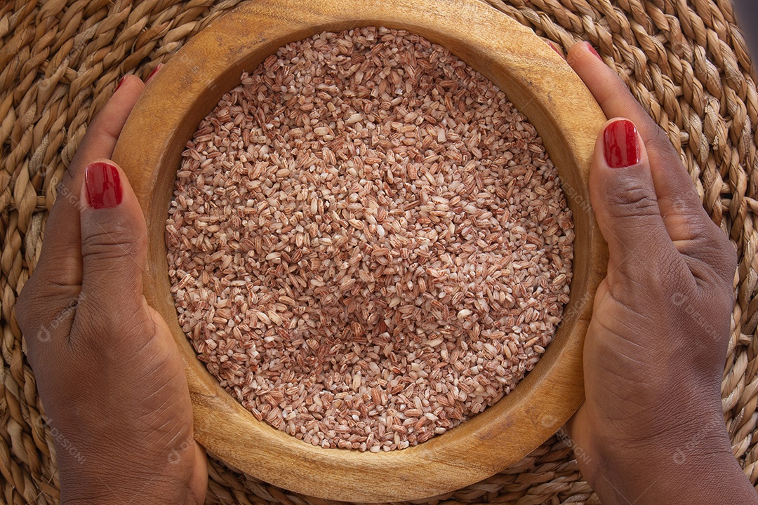 mãos segurando arroz orgânico e cru em uma tigela - comida