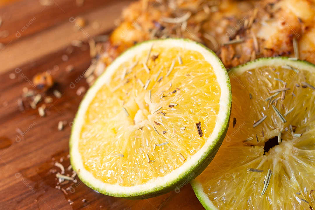 fatias de peixe frito com laranja e alecrim na mesa de madeira
