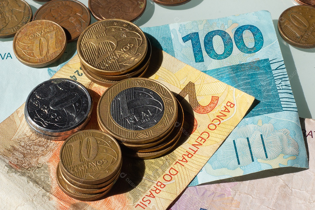vista superior de várias cópias de moedas e cédulas brasileiras