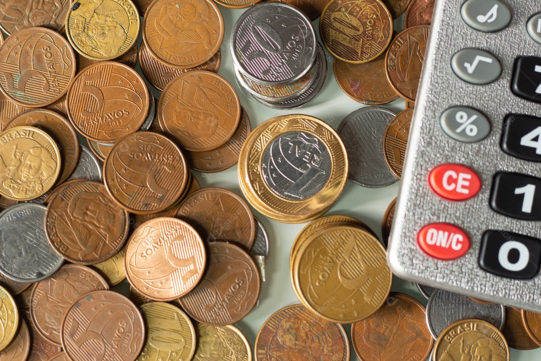 Calculadora cercada por moeda real brasileira